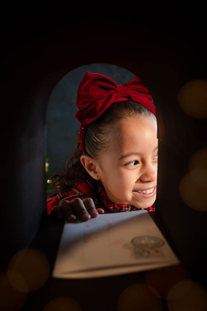 niña con carta a santa metiendola en el buzón en sesiones de navidad de aleiram fotografia